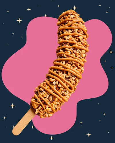 frozen banana dipped in chocolate covered in nuts and drizzled with peanut butter