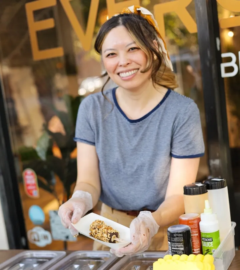 Woman holding a frozen banana dipped in chocolate